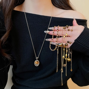 Detail view of tiger eye pendant necklace and matching beaded bracelets on model