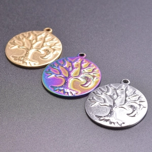 Detailed close-up of tree of life pendants in gold, silver, and iridescent rainbow finishes