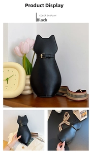 Detail of cat-shaped black patent leather handbag with red-white-black striped strap