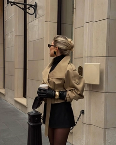 Trench-coat court kaki à col montant avec robe noire et accessoires de bijoux dorés