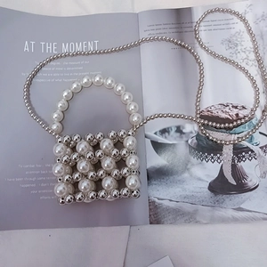 Detail of woven mini bag featuring oversized white pearls and silver metallic beads