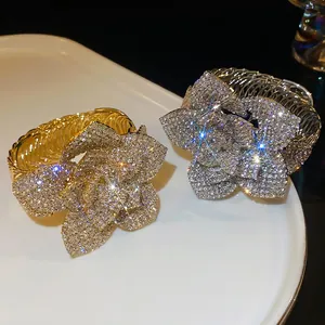 Adjustable floral cuff bracelet with crystals in gold and silver finish on white ceramic