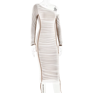 Détail d'une robe froncée à épaule dénudée crème avec passepoil marron contrasté et manches