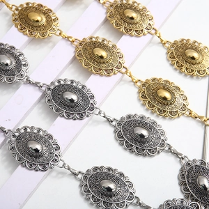 Detail of vintage carved metal waist chains in gold and silver for dresses