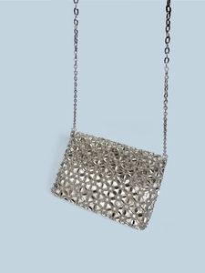 Close-up of silver woven hollow mesh bag with metallic sequins and elegant chain strap