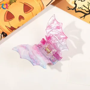 Close-up of Halloween bat hair claw clip with purple marble texture and gold spring