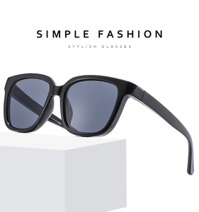 Detail view of stylish black square sunglasses with glossy frames on white display
