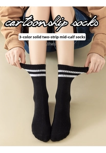 Detail showing elastic black crew socks with white stripes in a Japanese sport style