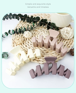 Close-up of matte wave-shaped hair claws in beige, light brown and dark purple colors