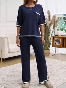 Détail de l'ensemble deux pièces en tricot bleu marine avec liseré blanc et pantalon large