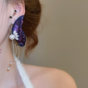 Detail of purple embroidered butterfly wing earring with crystals and metal tassels