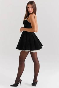 Detail of slim fit backless black mini dress with white lace hem and elegant puffy skirt