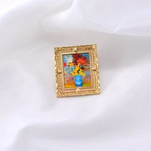 Vintage baroque gold frame brooch with floral oil painting over white fabric