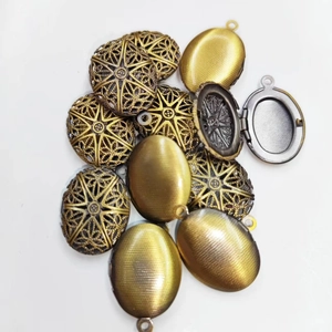 Detail of vintage hollow heart and frosted oval lockets in bronze and silver tones