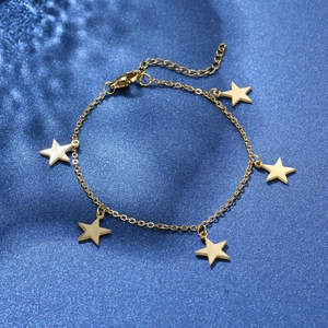 Gold stainless steel bracelet with five star pendants on star-themed dark blue background