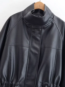 Detail view of the black leather jacket collar showing fine texture and contrast stitching