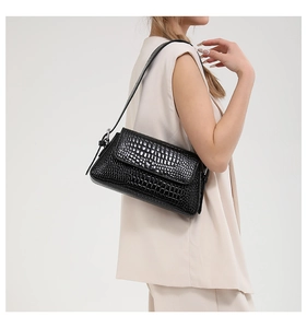 Detailed view of the black crocodile pattern texture on a stylish women's shoulder bag