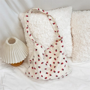 Gros plan du sac cabas en velours côtelé blanc avec imprimés fraises et texture douce