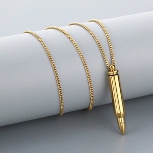 Detailed close-up of a polished gold stainless steel bullet pendant on a curb chain