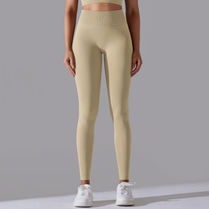 Detail of high-waist seamless yoga leggings with compression waistband in pale yellow