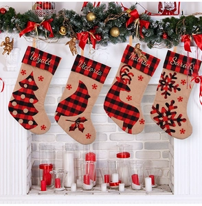 Red and black buffalo plaid Christmas stockings hanging on a white fireplace mantel