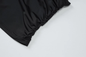 Detail view of smooth black fabric texture with side ruching and double-needle stitching