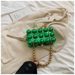 Detail view of green bubble-textured acrylic egg bag with elegant golden beaded chain strap