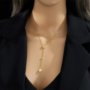 Elegant gold Y-shaped necklace with crystal-inlaid ring pendants on a model in a black suit