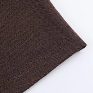 Close-up of dark brown knit dress featuring durable double-needle stitching and fabric texture