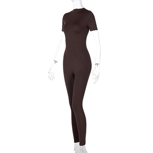 Detail view of a dark brown short sleeve yoga jumpsuit featuring a slim fit and front zipper