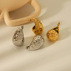 Detail of 18K gold and silver stainless steel earrings with textured hammer finish
