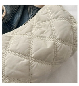 Gros plan sur les coutures matelassées en losange d'un sac en nylon beige élégant