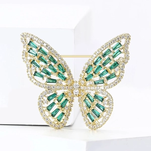 Detail of butterfly brooch with green emerald-cut stones and clear zircon crystals