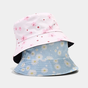 Double-sided floral bucket hats in pink cherry blossom and blue daisy cotton fabric