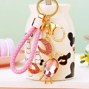 Detail of crab keychain with pink gemstone, sparkling diamonds and pink woven cord