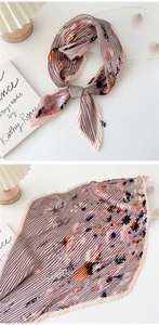 Detail view of pink pleated skinny scarf with abstract floral print and wavy edges