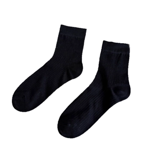 Minimalist black combed cotton socks with ribbed texture on a white background