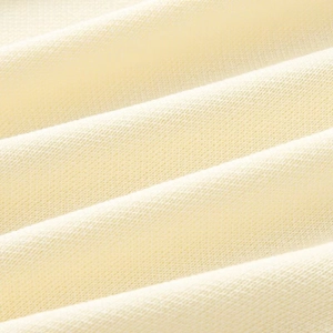 Close-up of soft cream knitted fabric showing detailed texture and high-quality weaving