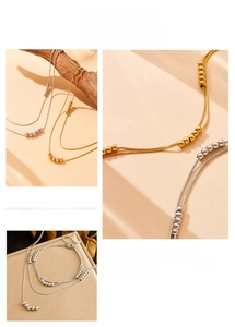 Detail view of multi-layer beaded snake chain set with lobster clasp and gold finish