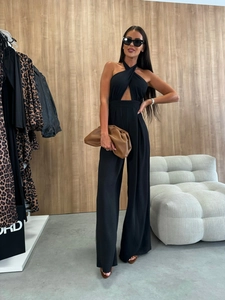 Detail of black halter jumpsuit showing cross neckline and diamond cut-out at the waist