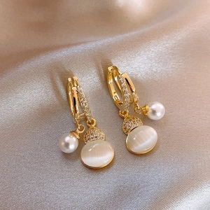Golden double hoop earrings with white opal, pearl, and zircon on champagne silk fabric