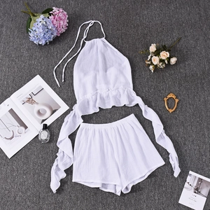 Flat lay of white halter neck top and ruffle shorts set with leisure accessories