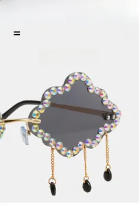 Detail of cloud-shaped sunglasses with gradient AB rhinestones and gold chain droplets