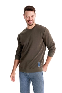 Detail of olive green sweatshirt fabric with fashion trends tag on ribbed hemline