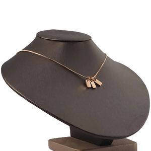 Detail of rose gold rectangular charm pendants on a minimalist box chain necklace