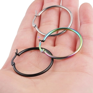 Detalle de pendientes de aro grandes de acero inoxidable en plata, arcoíris y negro