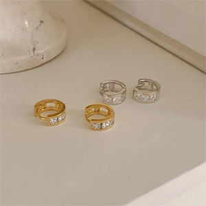 Minimalist gold and silver hoop earrings with cubic zirconia pave on a white surface