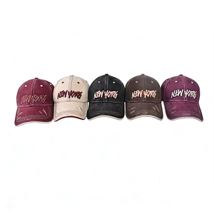 Flat lay of distressed cotton baseball caps with New York embroidery in five colors