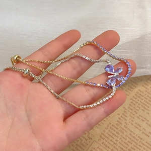 Bracelet double chaîne plaqué or avec papillon en zircon violet et fermoir ajustable