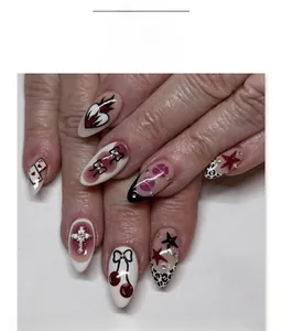 Detail of almond-shaped fake nails featuring 3D cross, bows and leopard patterns